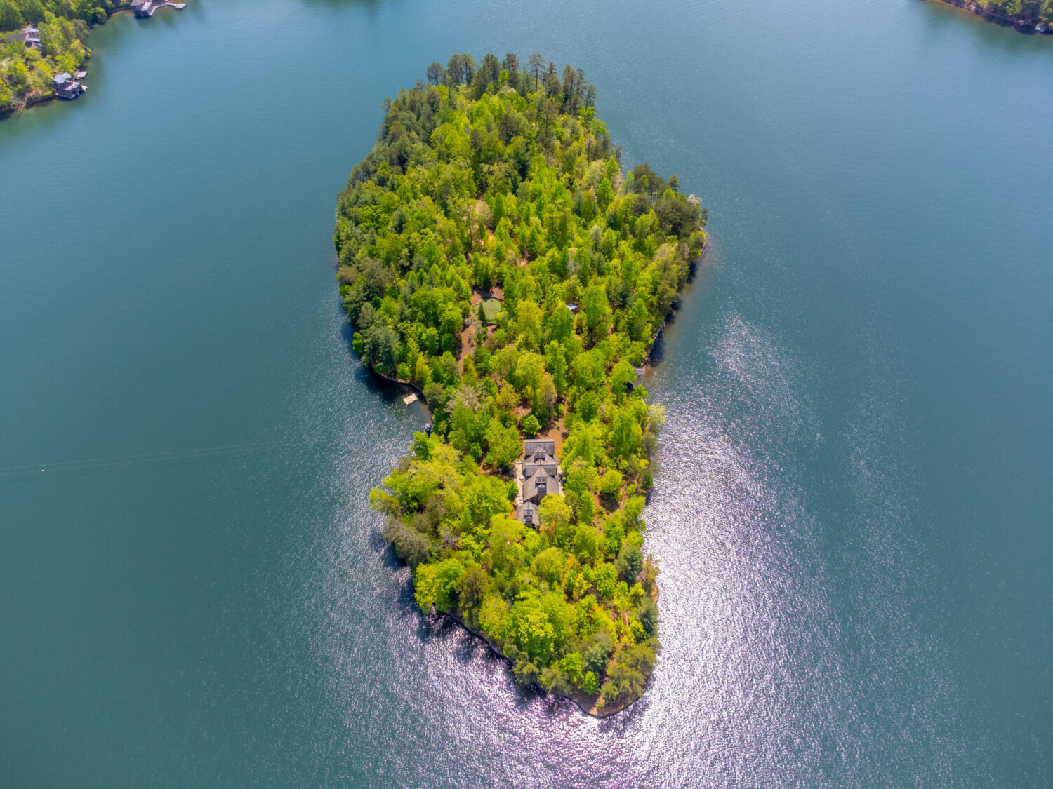 Aerial view of private island estate on Lake Burton surrounded by blue water