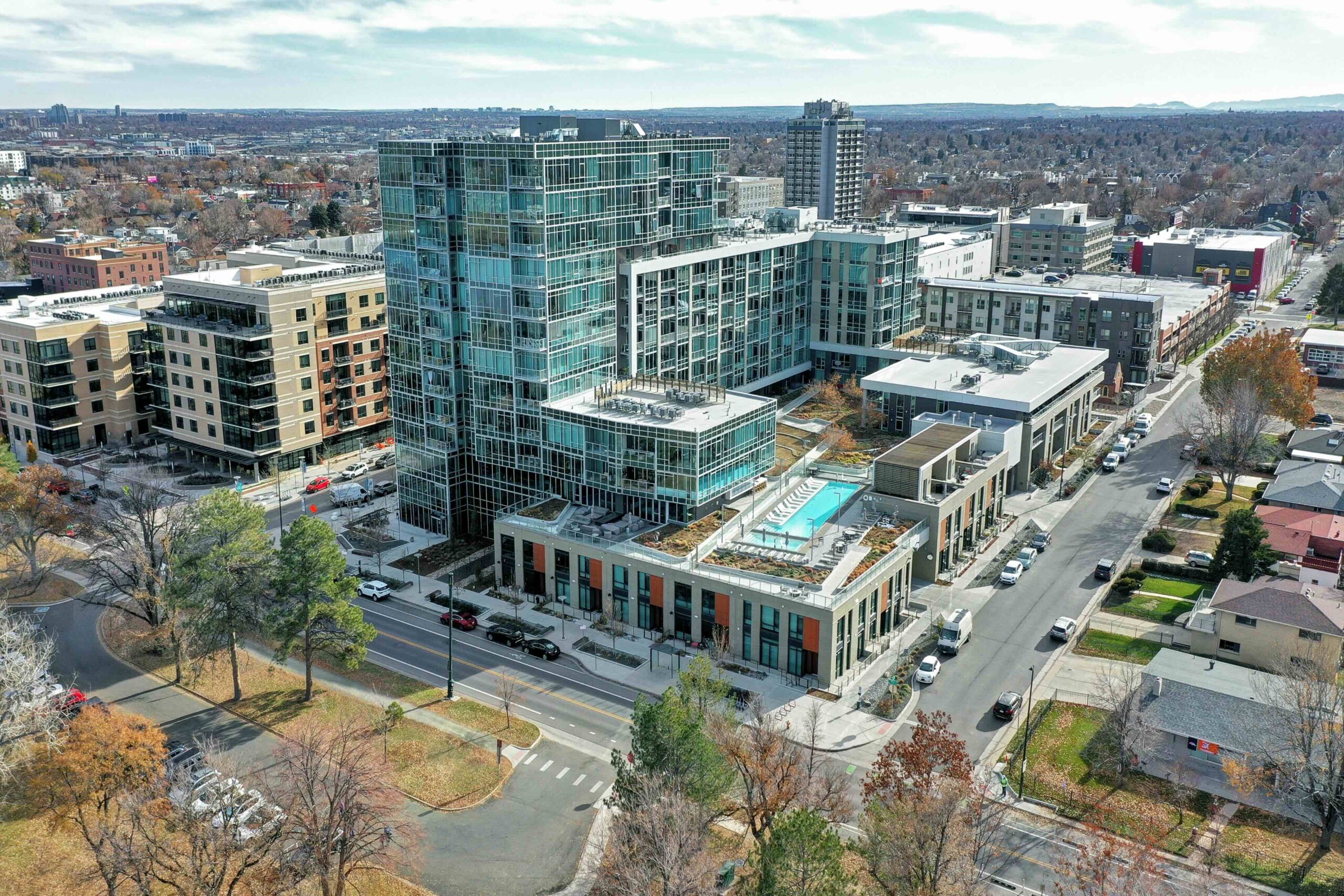 Aerial view of Lakehouse luxury condo complex in Denver’s Sloan’s Lake neighborhood, featuring a rooftop lap pool and modern glass architecture.