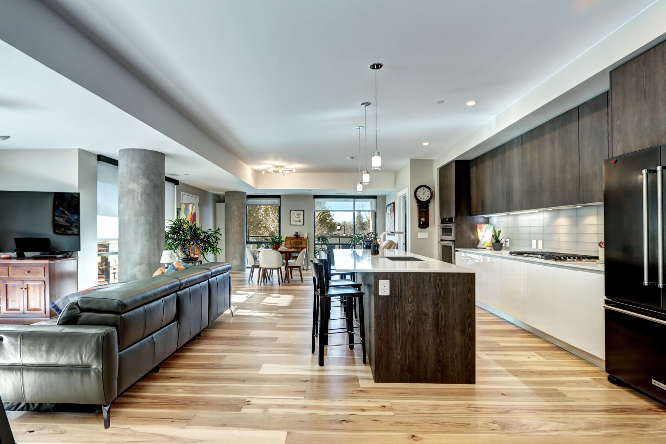 Modern open-concept kitchen with ITALKRAFT cabinetry, quartz countertops, and stainless-steel appliances inside the Lakehouse condo.