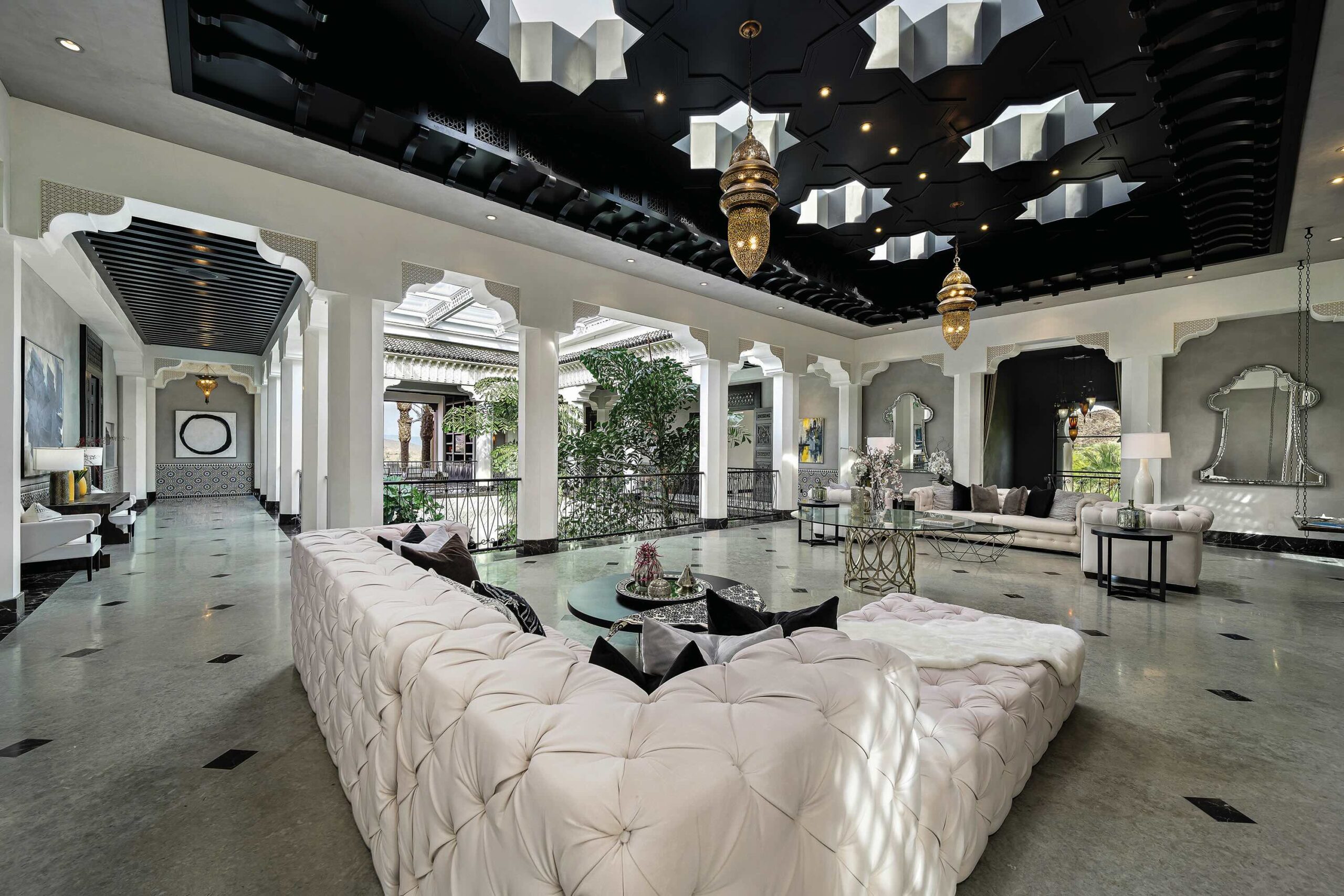 Interior and courtyard of Casbah Cove in Palm Desert, California—featuring ornate Moroccan arches, white columns, lush greenery, and an open-air courtyard with a central fountain.