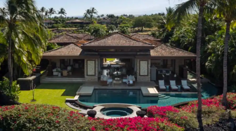Magnify outdoor living with various seating options under the covered lānai. Enjoy the built-in barbecue station with refrigerator and prep sink, spacious lawn and inviting pool.