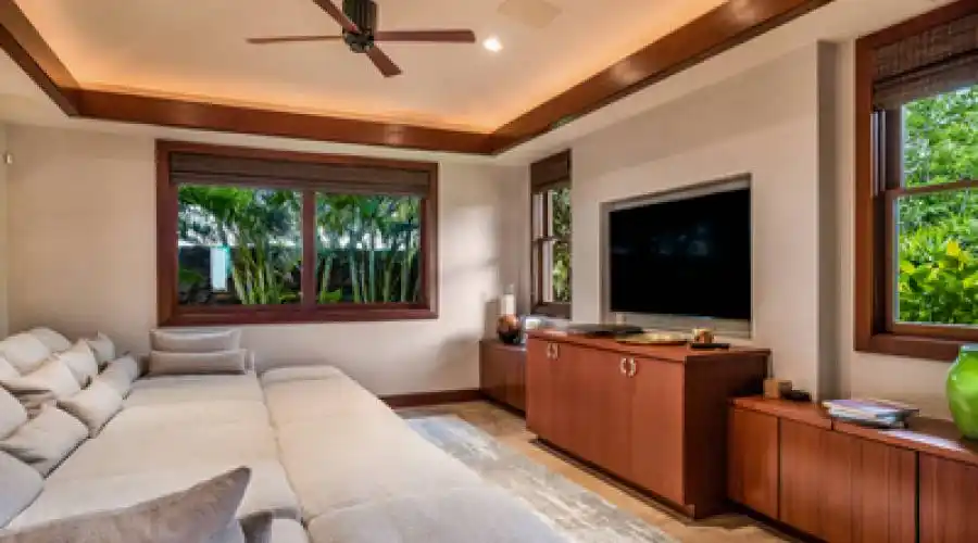 Comfortable media room is conveniently set off the kitchen and features a built-in entertainment cabinet.