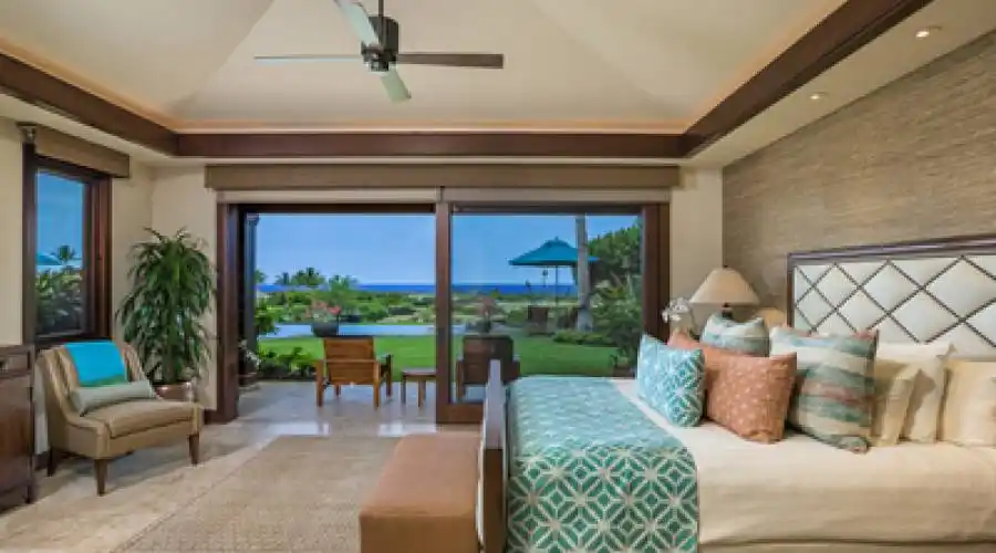 Master bedroom steps out to the grassy lawn and pool area overlooking panoramic ocean vistas.
